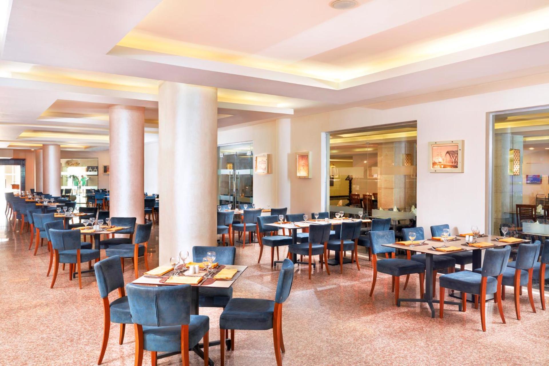Hotel Royal Albatros Moderna - Families and couples only à Charm el-Cheikh Extérieur photo The photo shows a spacious restaurant interior. It features several sets of tables and chairs arranged in a well-organized manner. The tables are dressed with placemats and utensils, indicating they are prepared for dining. The color scheme includes 